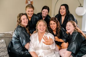 Wedding party wearing matching black leather jackets pose together during pre-ceremony preparations.
