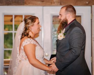 Joyful moment during wedding ceremony with couple holding hands.