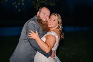 A joyful couple embraces and laughs together during their evening celebration.