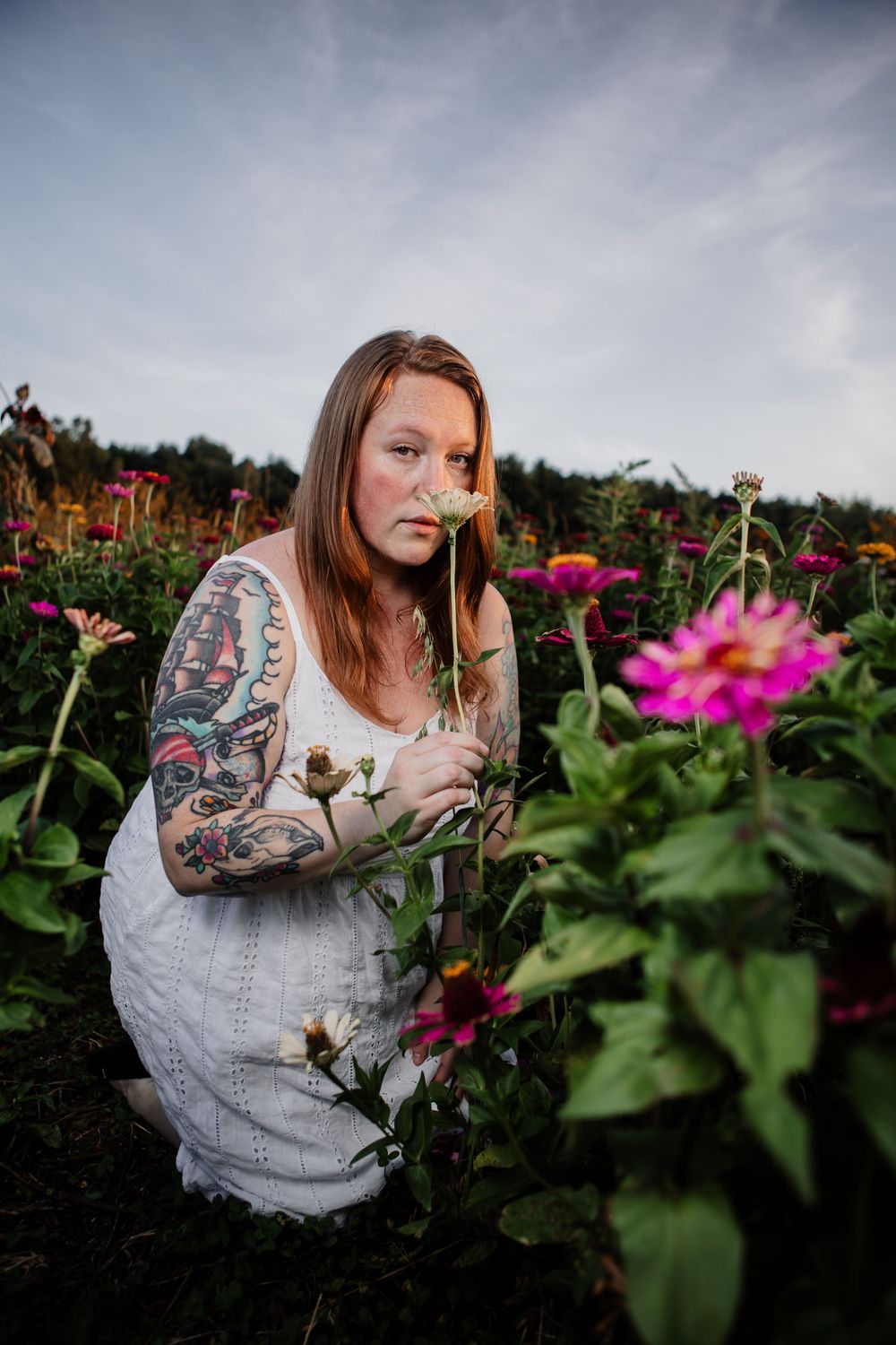Artistic portraits in a flower garden with pink zinnias and natural lighting.