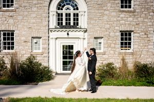 Bride and groom share a first look outside a historic stone building on their wedding day.