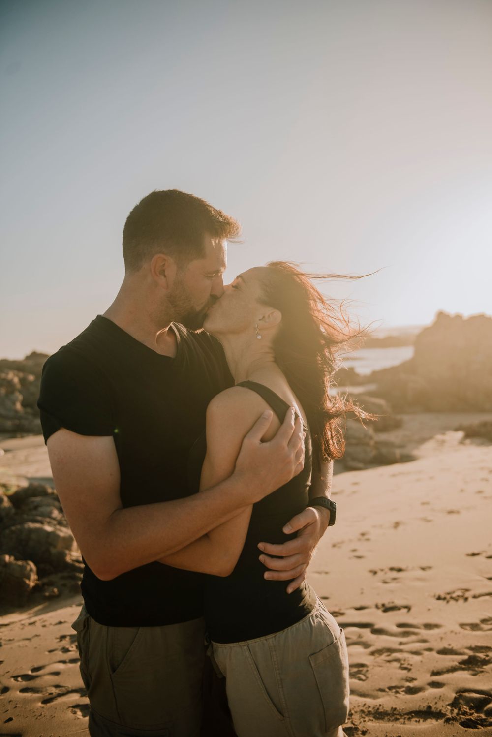 Couple kissing on Buffels bay beach during sunset