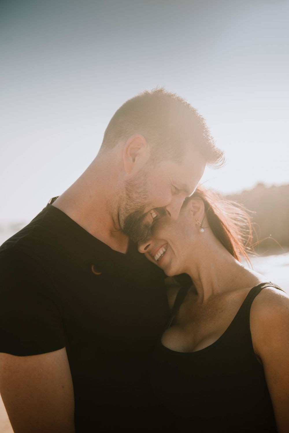 Couple embracing on Buffels bay beach during sunset