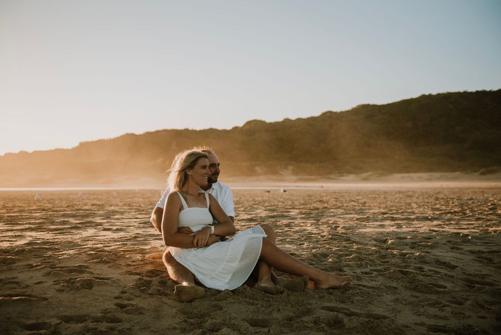 Couple embracing during golden hour with warm sunset light in the background on Hartenbos beach