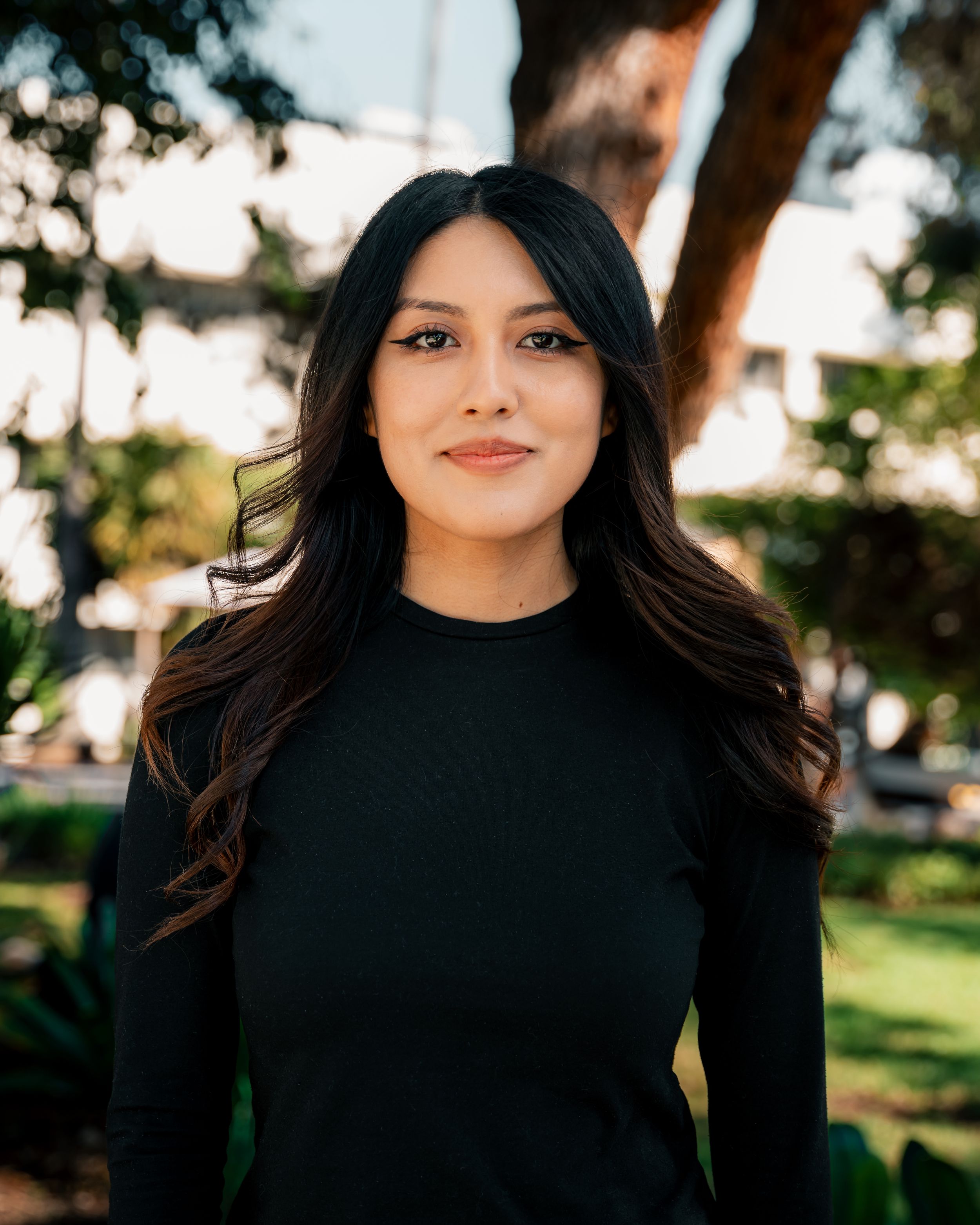 Portrait series outdoors featuring a person in a black top with trees in background.