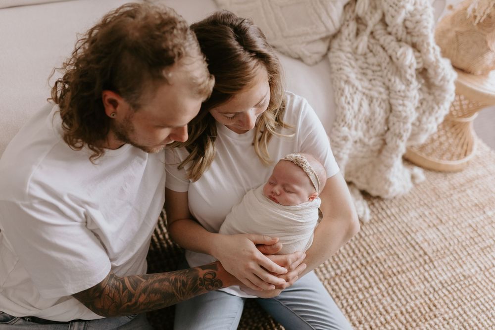 A tender moment between parent and baby captured in a series of intimate black and white photographs.