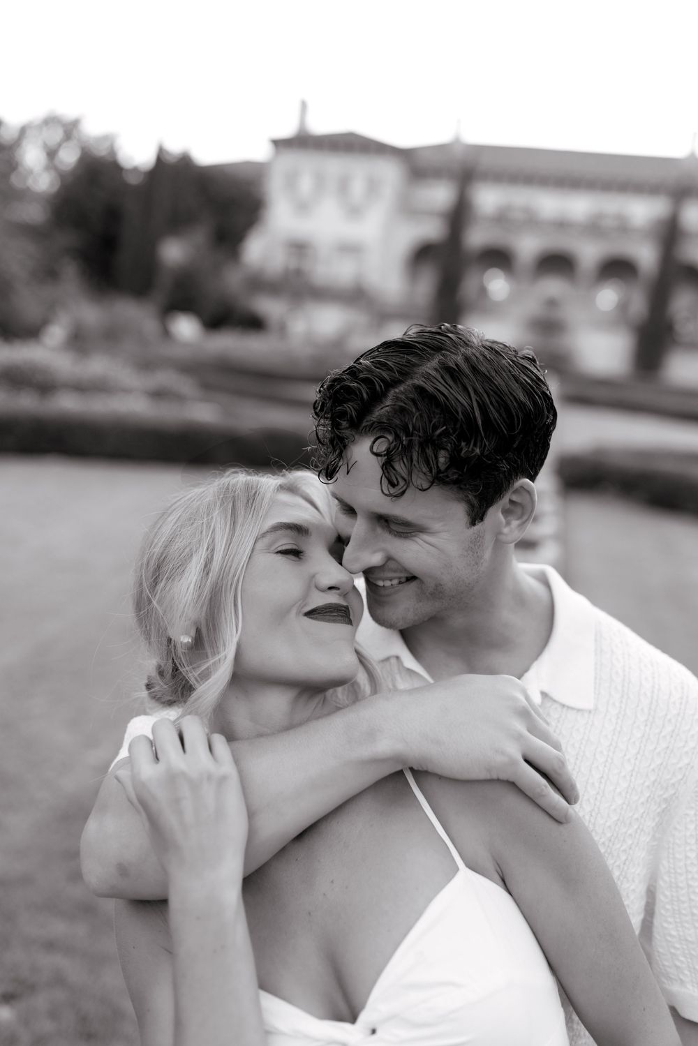 A romantic black and white photo sequence shows a couple in white clothing sharing intimate kisses by the water.