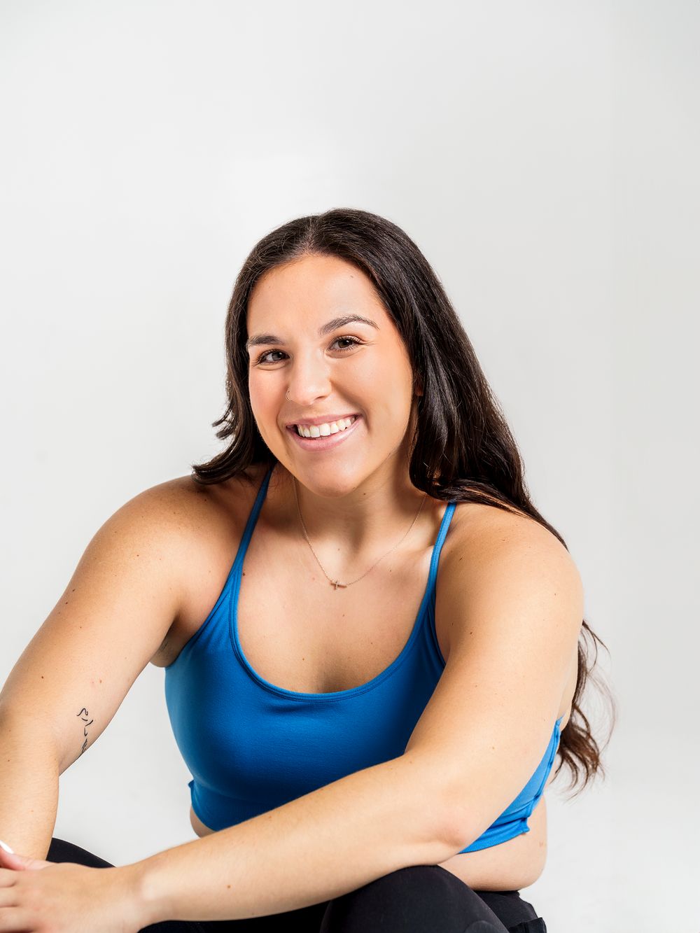 Athletic portrait against white background wearing blue tank top.