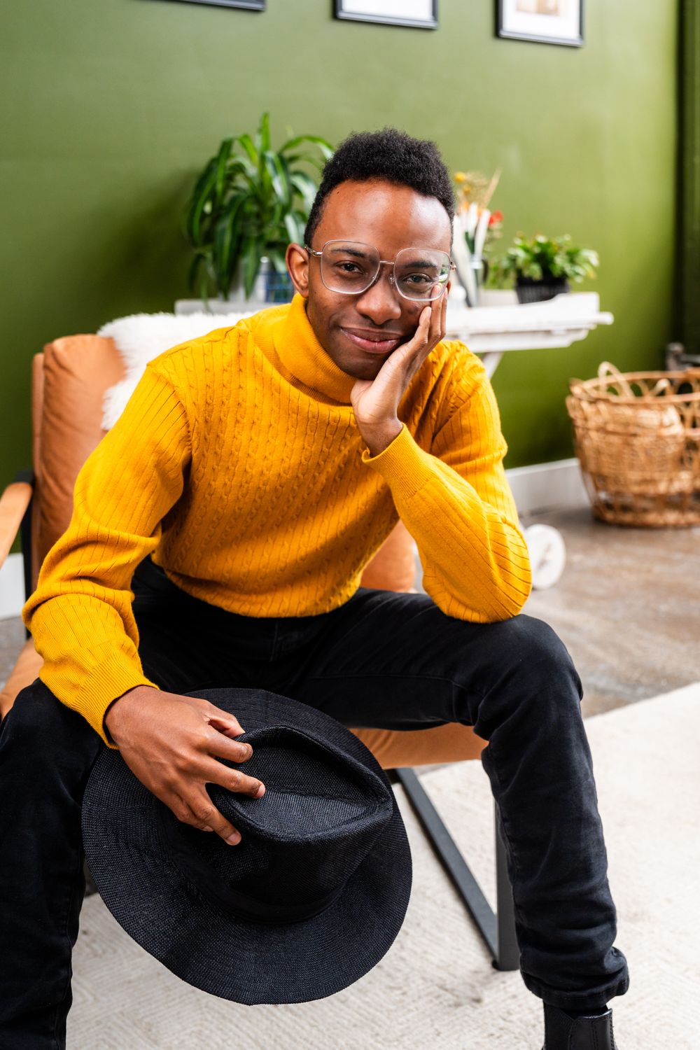 Person in yellow sweater sitting casually in modern interior setting.