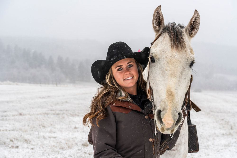 Winter wonderland photo session with a majestic white horse in snowy conditions.