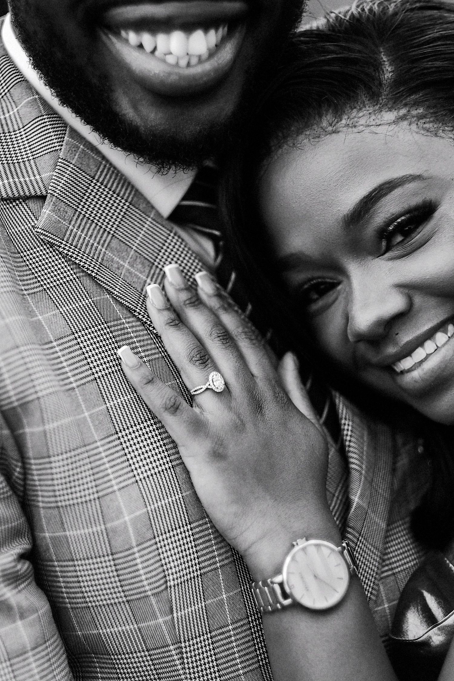 Black and white engagement photo showing ring and watch details with intimate pose.
