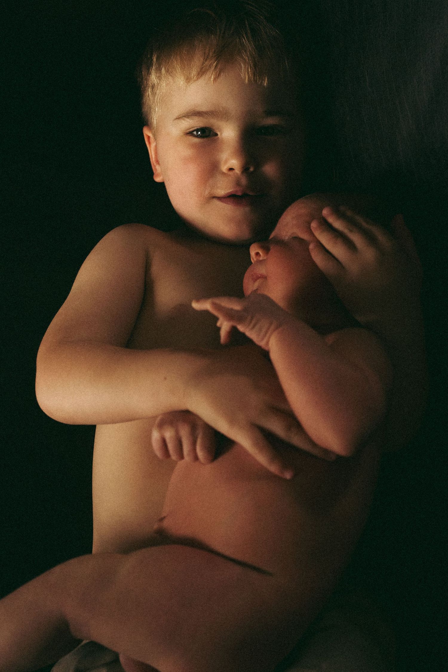 Artistic low-light portraits showing tender embraces and gentle movements.