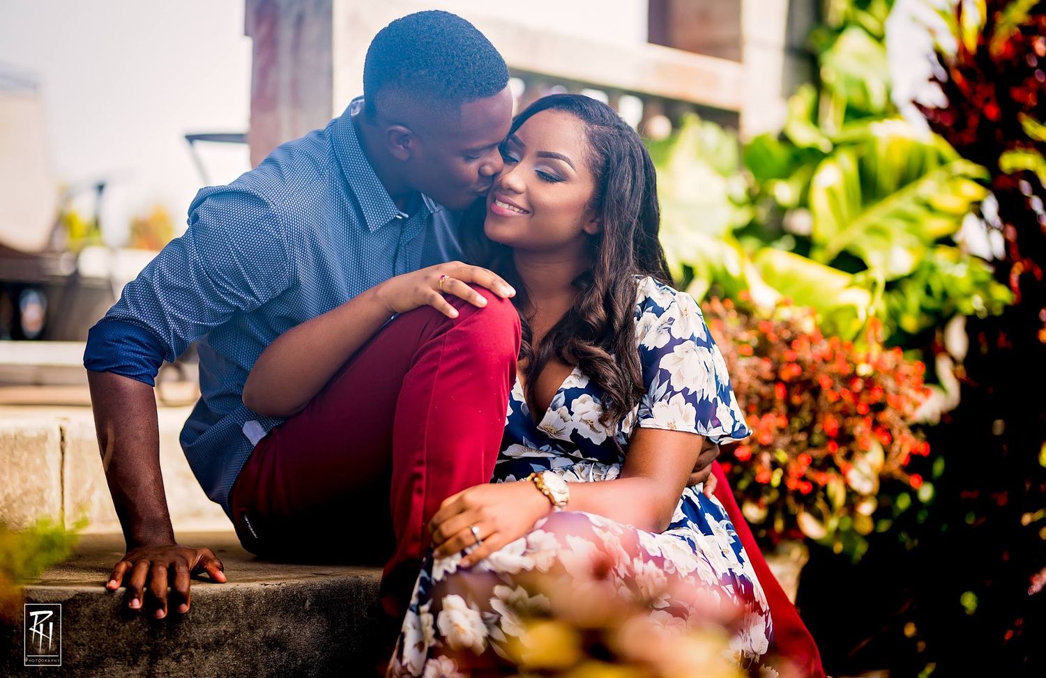 Casual couple sitting on outdoor steps during engagement photoshoot.