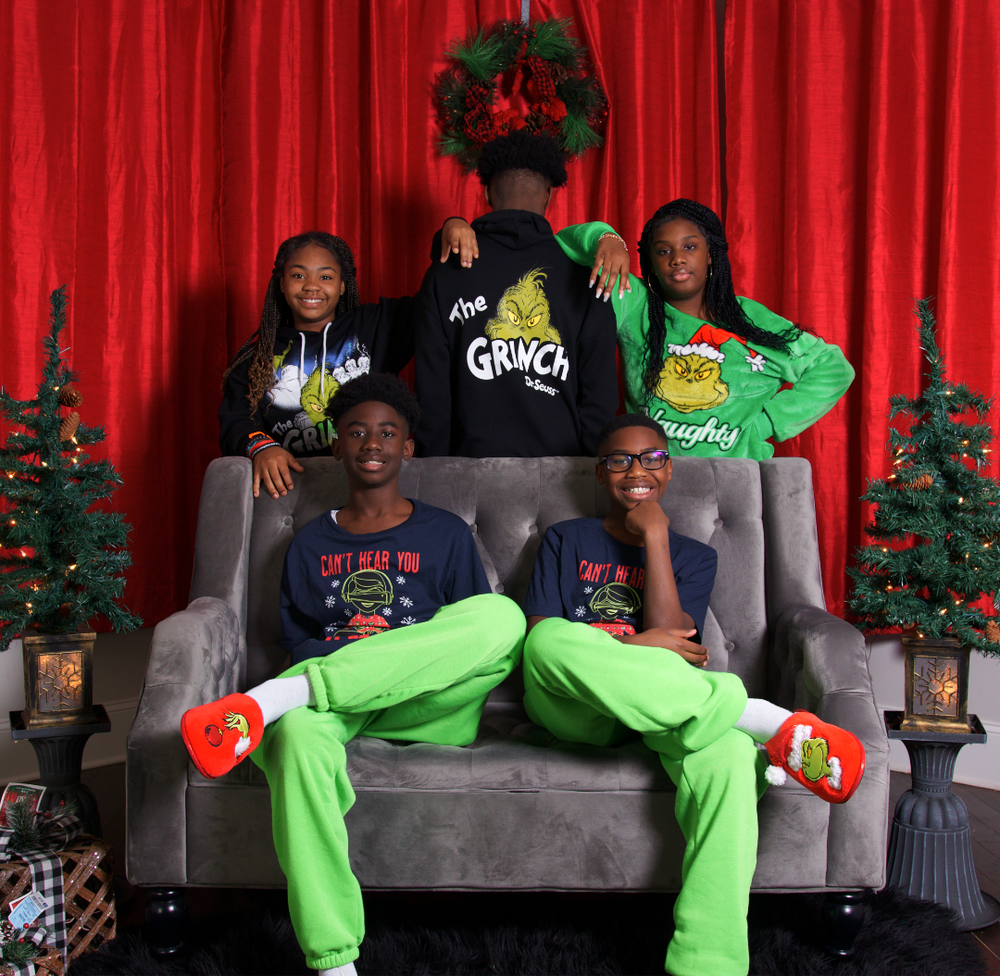 Family Christmas photoshoot in matching pajamas by decorated tree