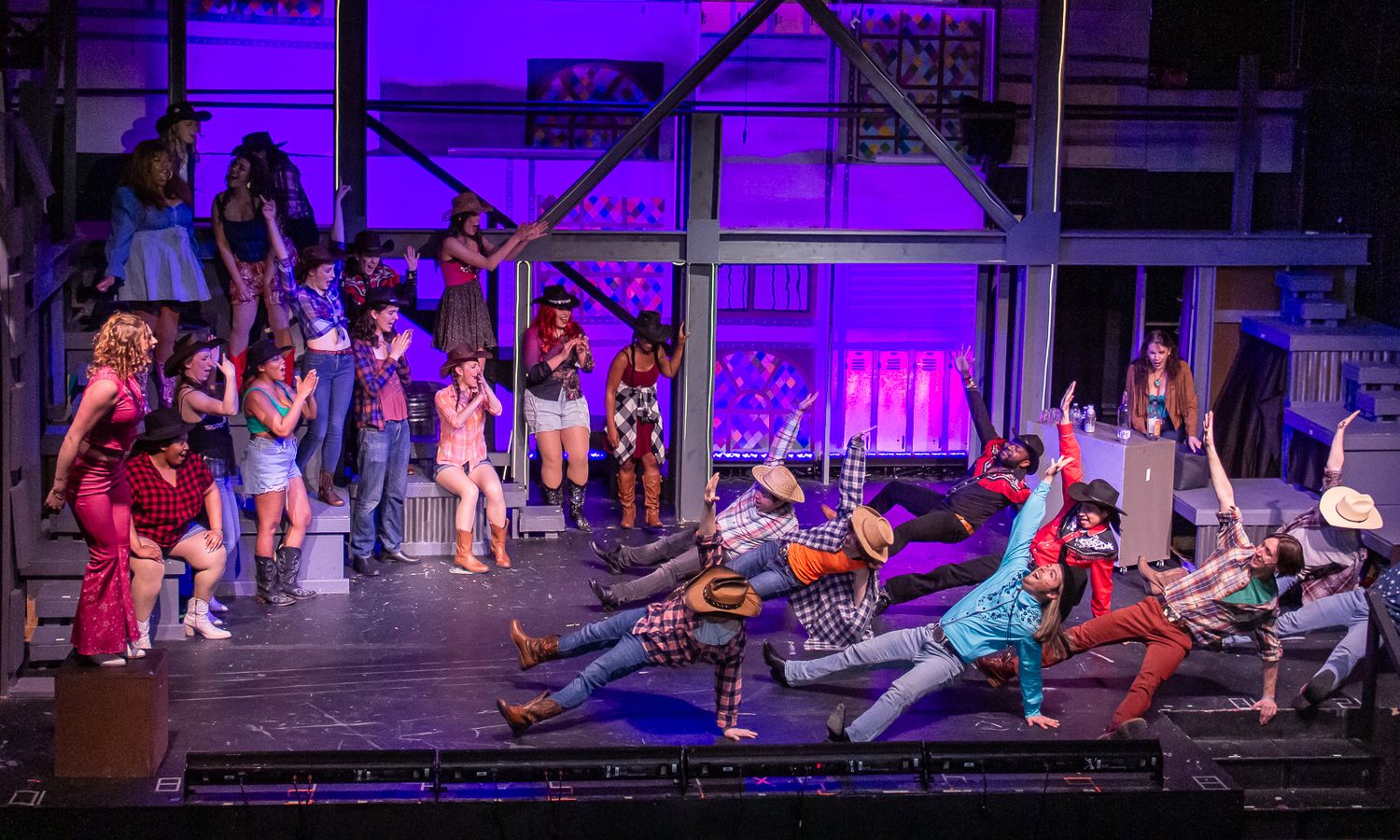 Theater performers in colorful costumes during dynamic stage production.