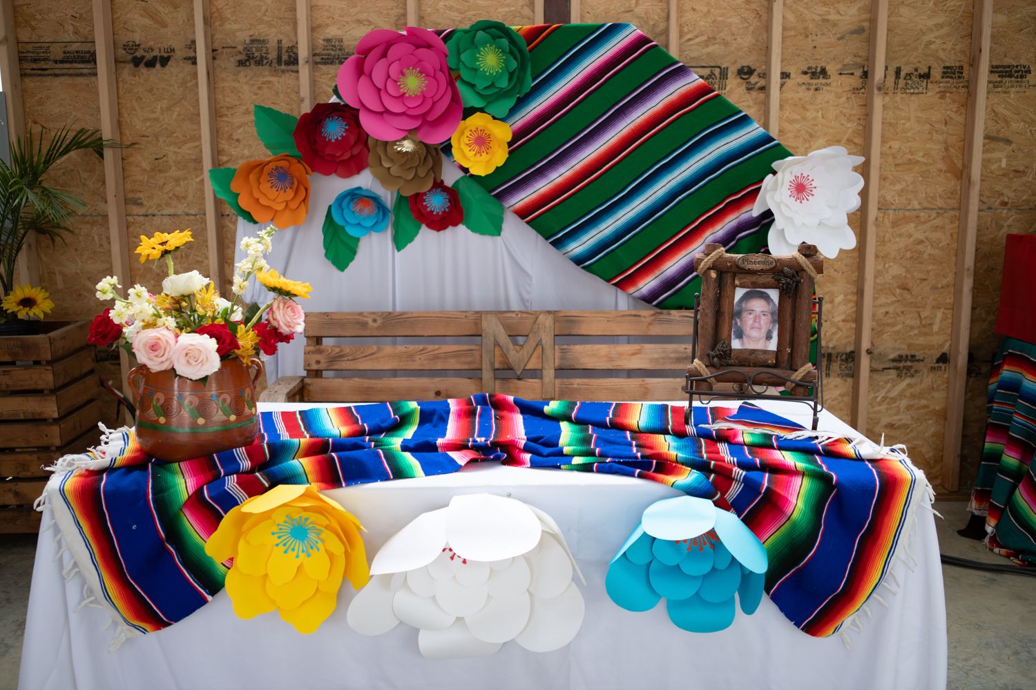 Colorful Mexican fiesta themed party display with serape blankets and paper flowers.