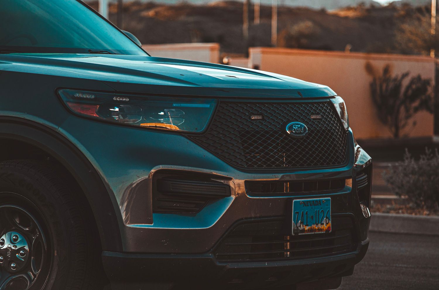 Close-up of a Ford police interceptor SUV's front grille and headlights at sunset.