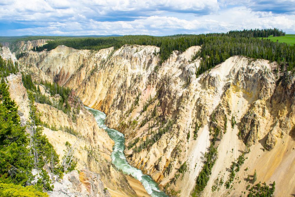 Grand Canyon of Yellowstone with turquoise river flowing through dramatic yellow stone cliffs.