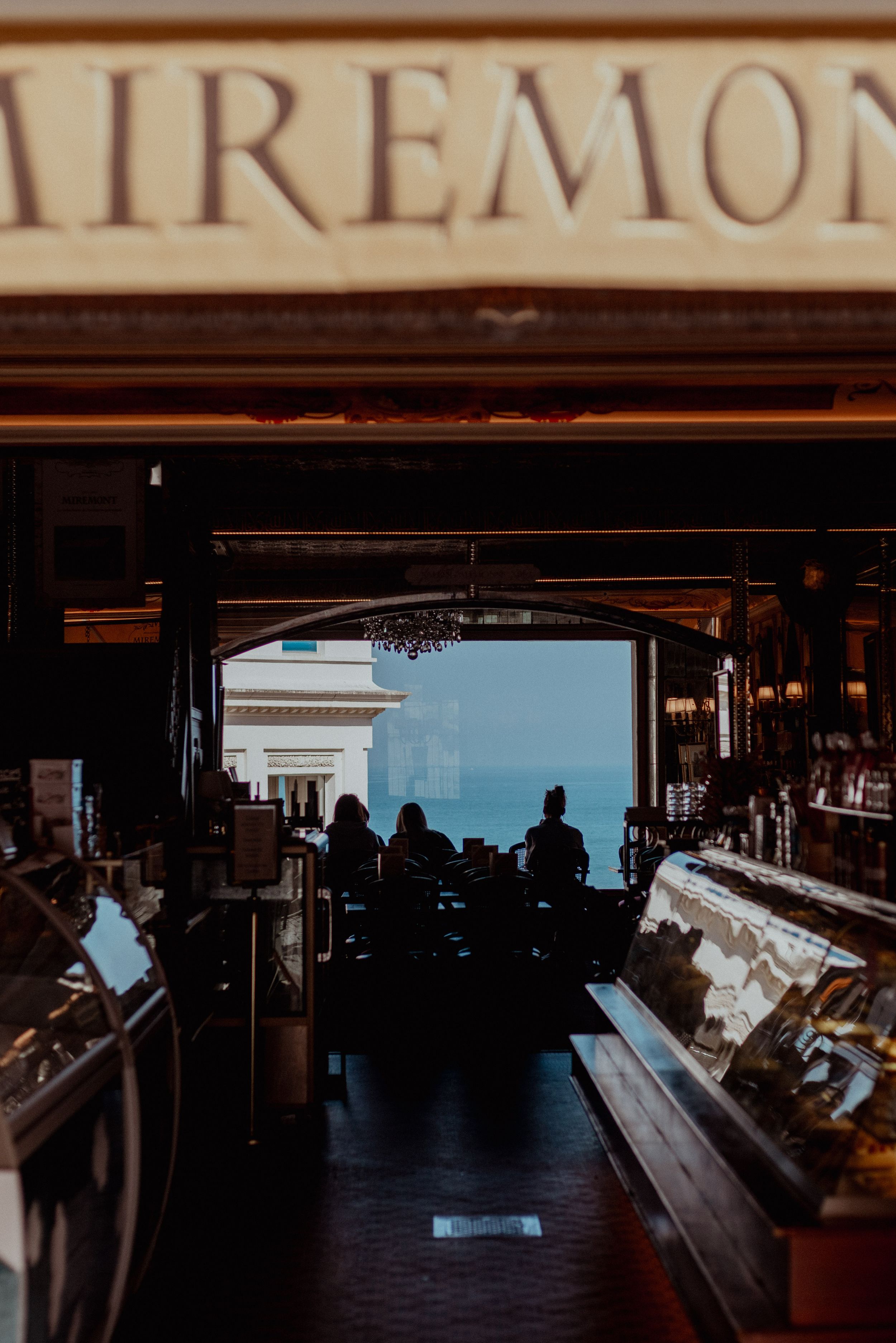 Dark interior view of the Claremont shop entrance with silhouettes visible against bright daylight.