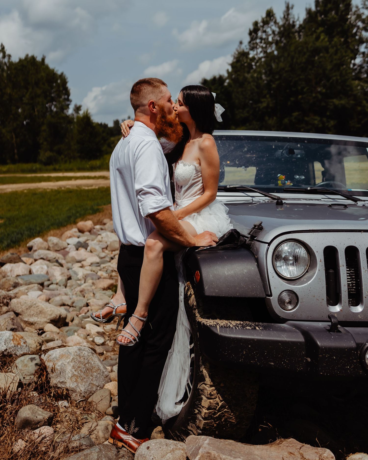 Romantic moment shared between newlyweds against their Jeep during outdoor photo session.