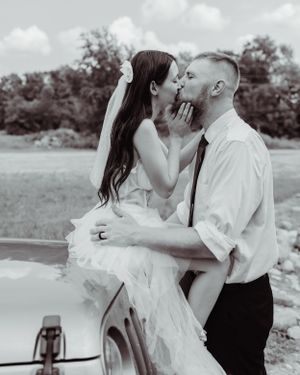 A romantic black and white moment captured of a couple against their Jeep during their wedding.