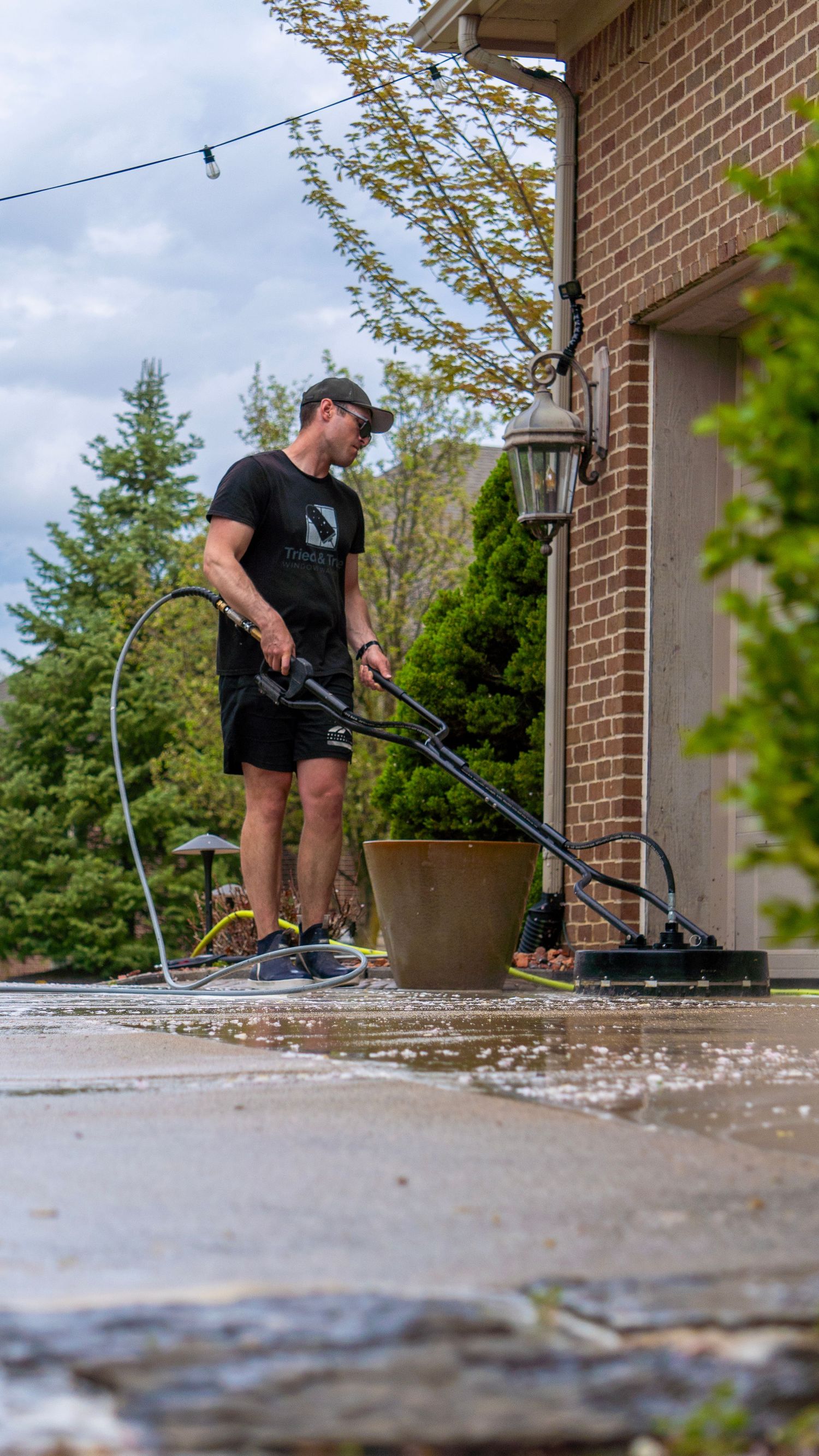 A man power washing a driveway