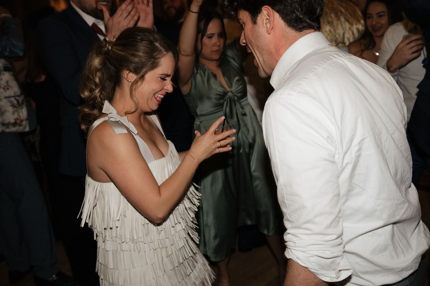 A couple dances together on the dance floor at a wedding reception.