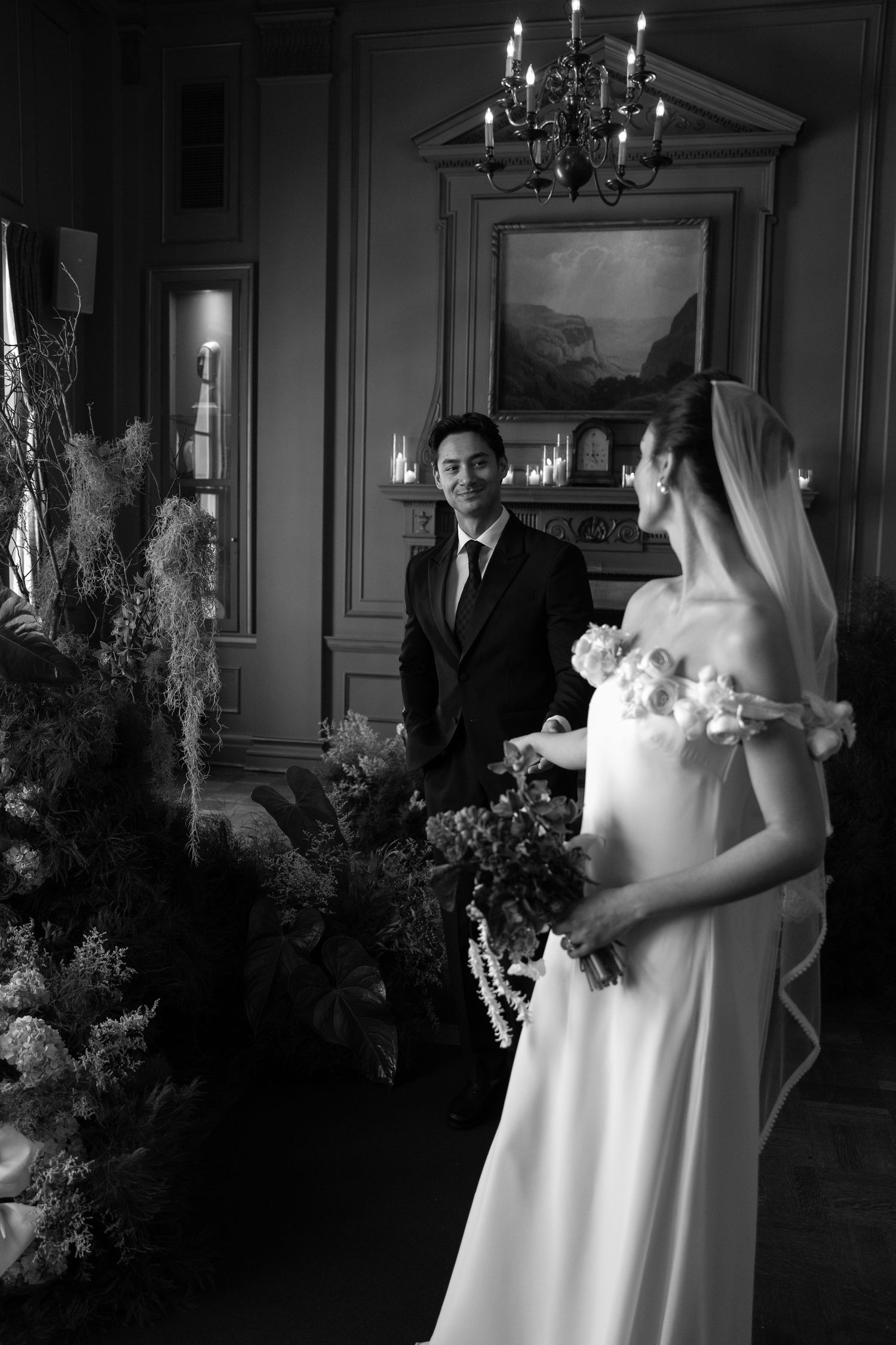 Black and white elegant wedding ceremony in a grand room with ornate architectural details.