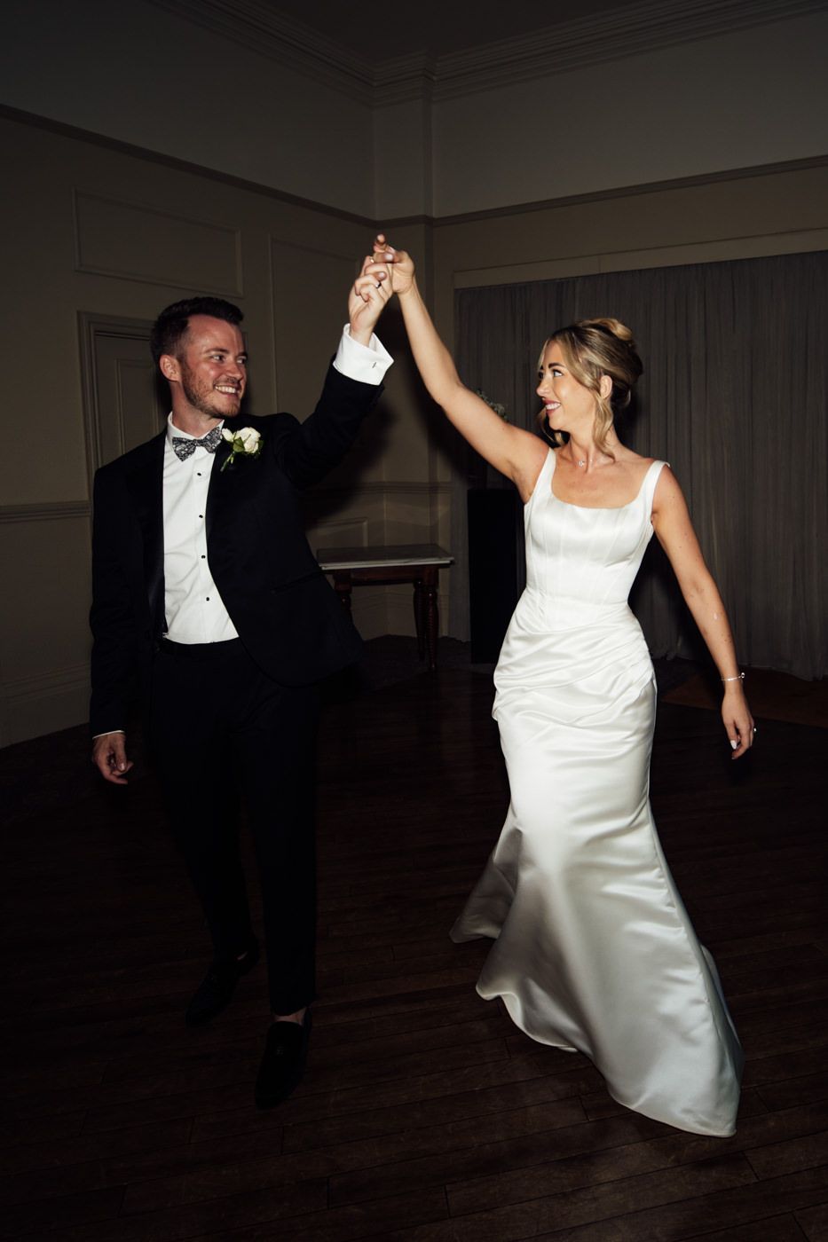 First dance at a wedding reception, with the bride in a white gown and groom in a tuxedo. Peterstone court.