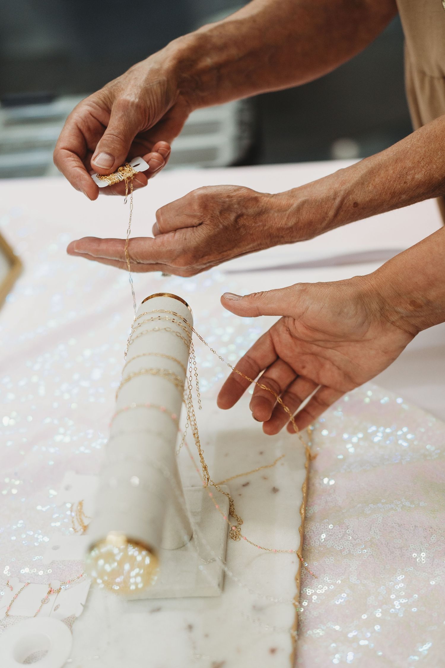 Close-up of hands wrapping a white cylindrical object with string or twine.