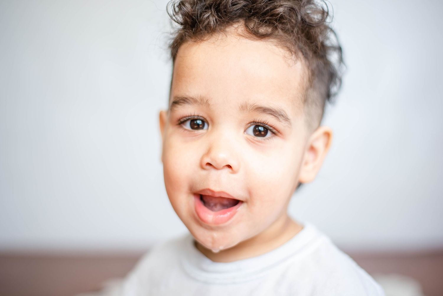 Close-up portrait showing expressive facial features against white studio background.