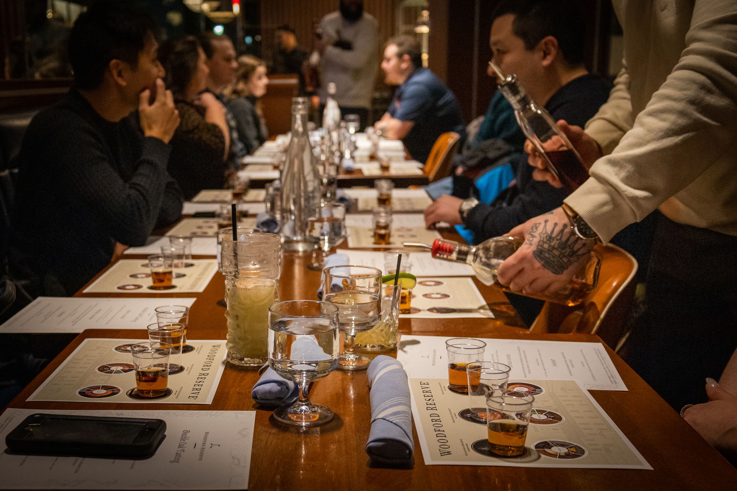 Group tasting event with multiple glasses and tasting notes arranged on a wooden table.