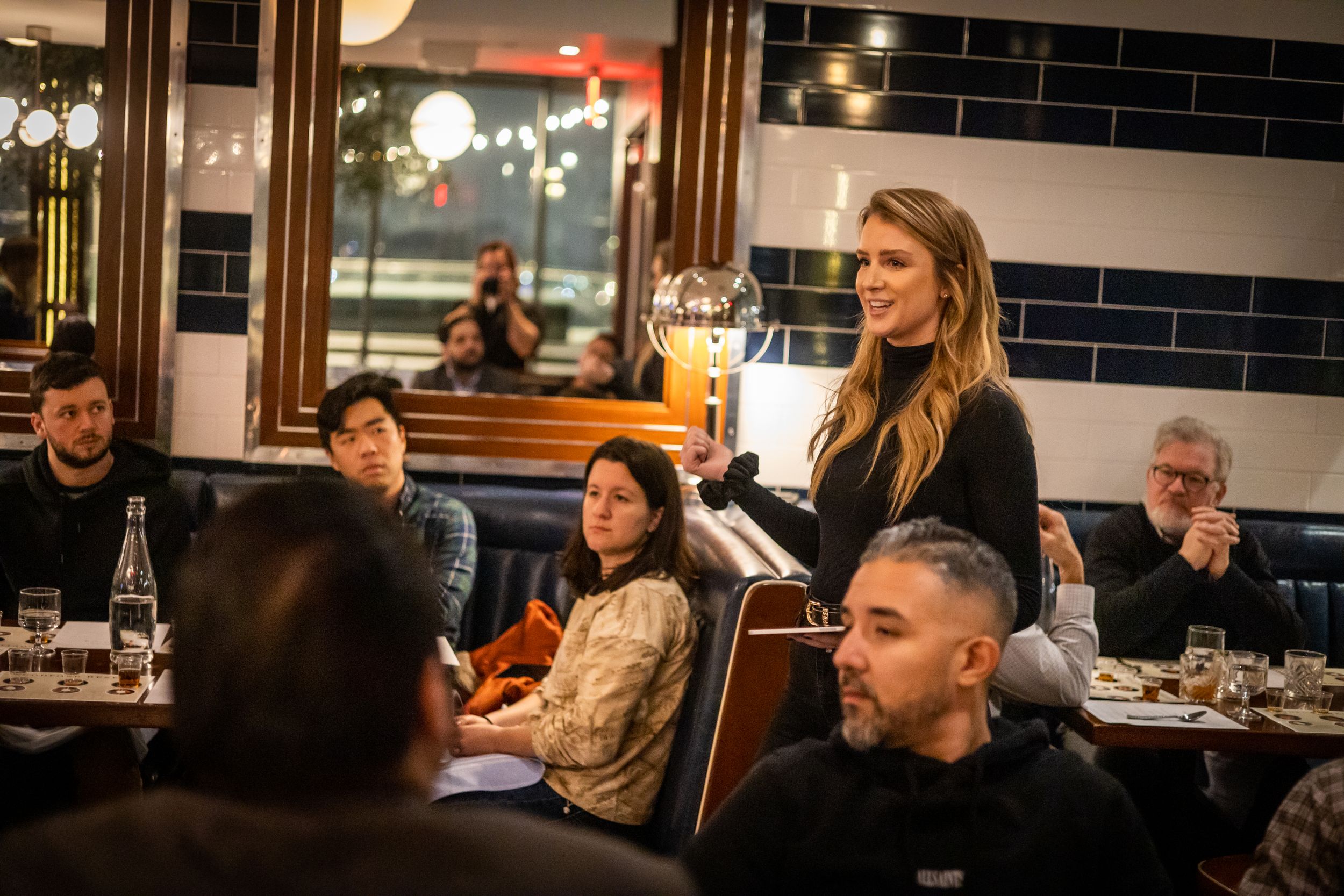Elegant restaurant interior with diners seated at tables during evening service.