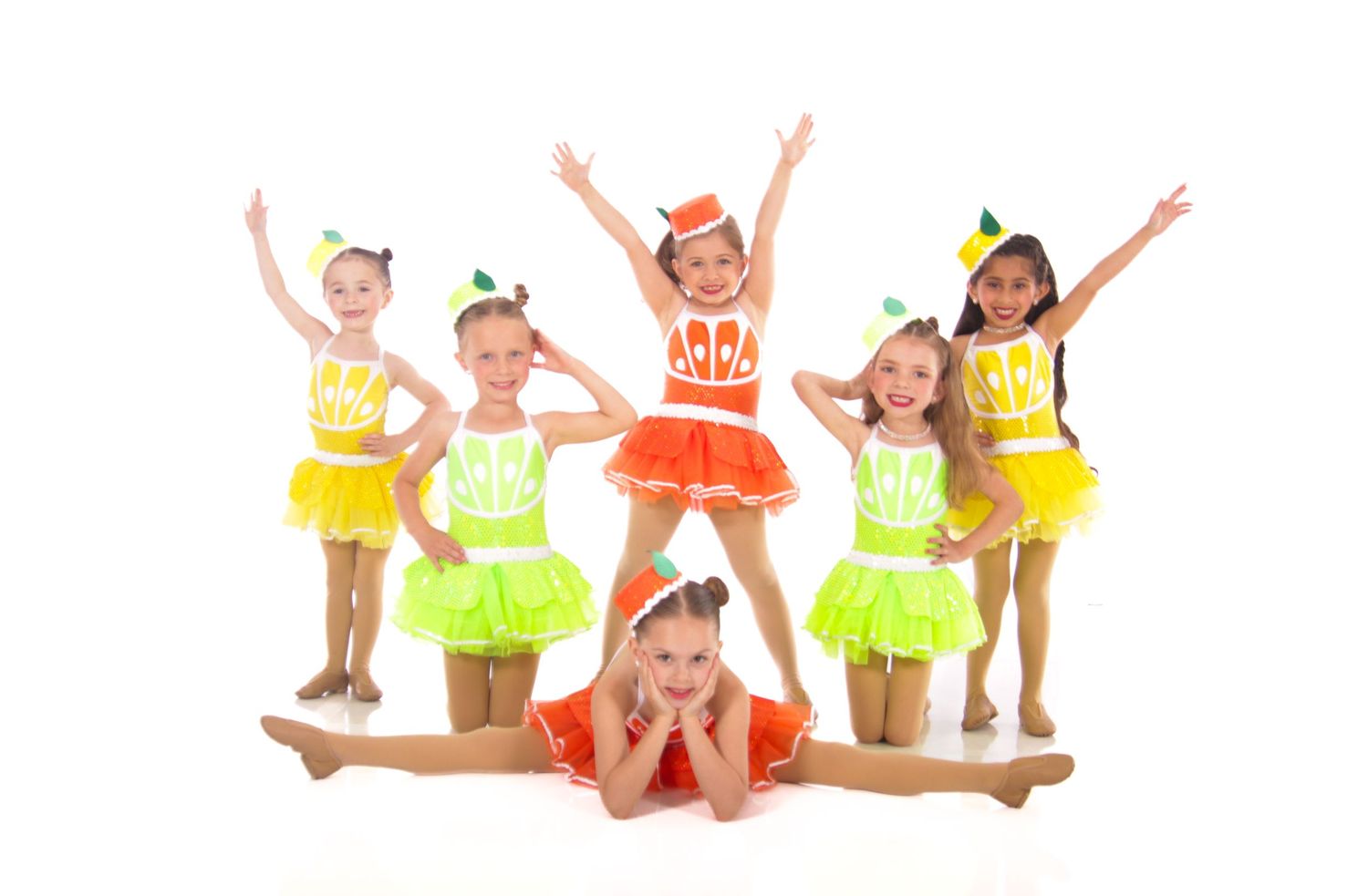 Group of cheerleaders in yellow and white uniforms posing and jumping with energetic expressions.