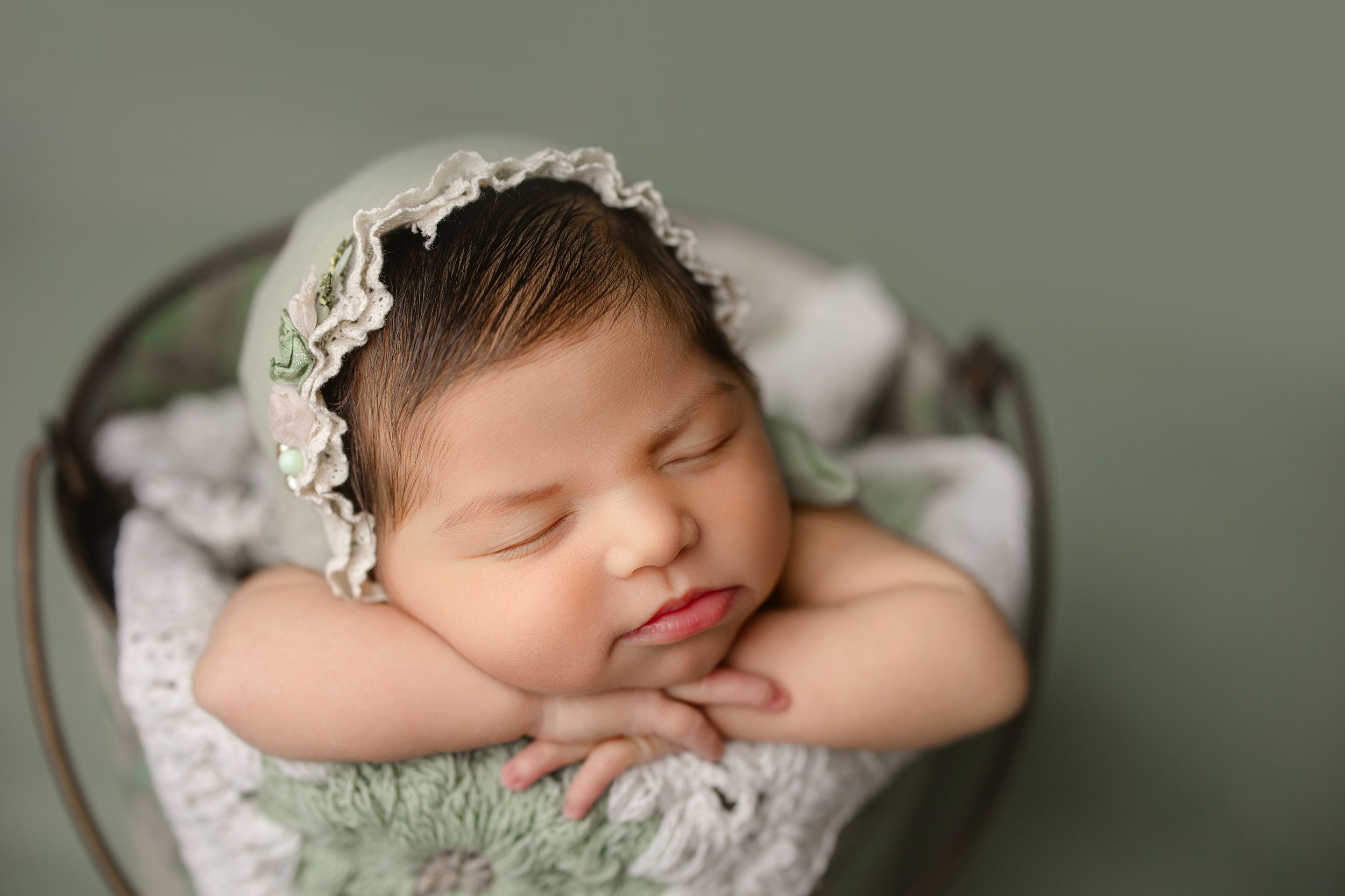 Peaceful newborn baby sleeping on soft green blanket with lace details. Middle TN newborn photographer.