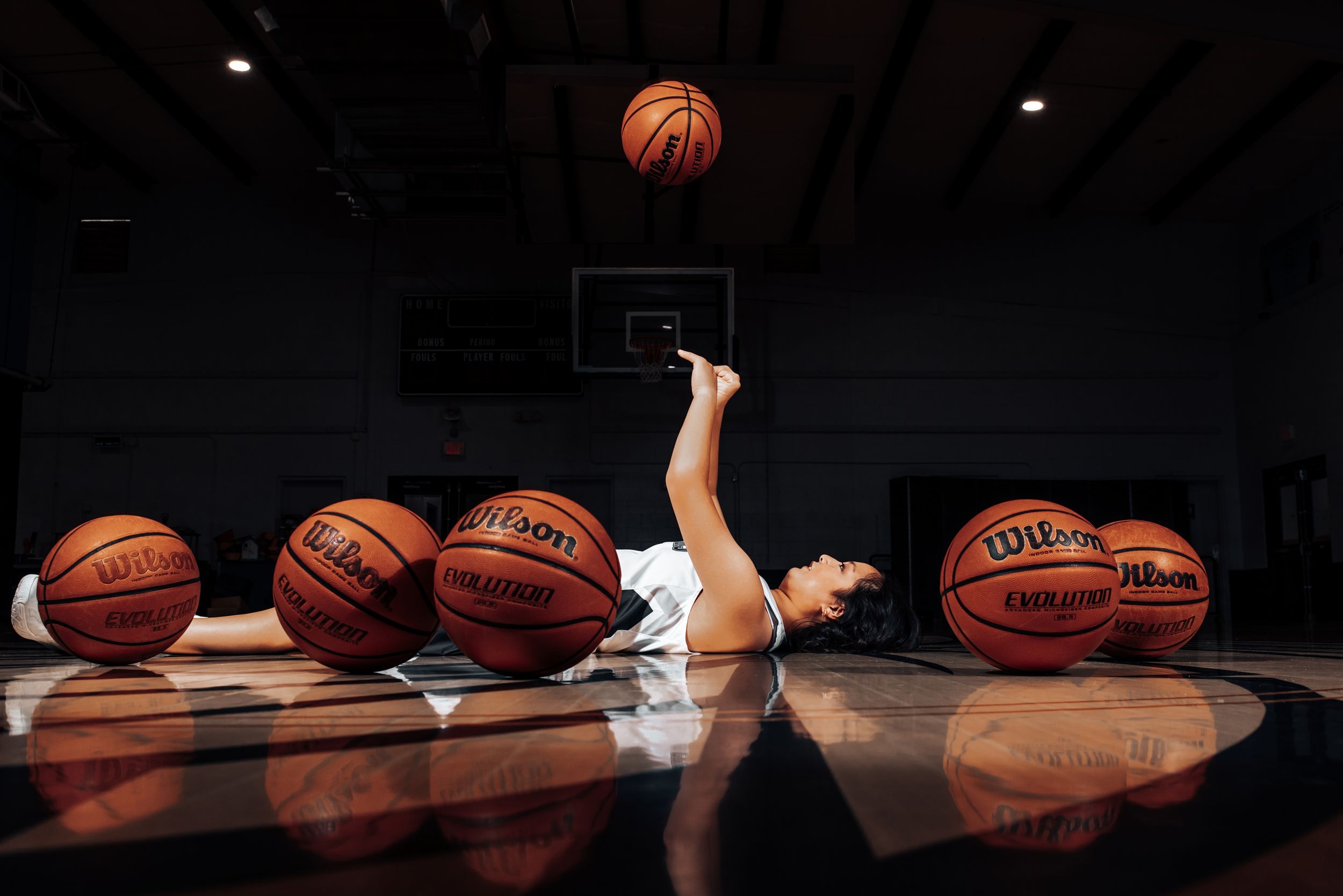 Multiple Wilson basketballs arranged in a dark studio setting with dramatic lighting and reflections.