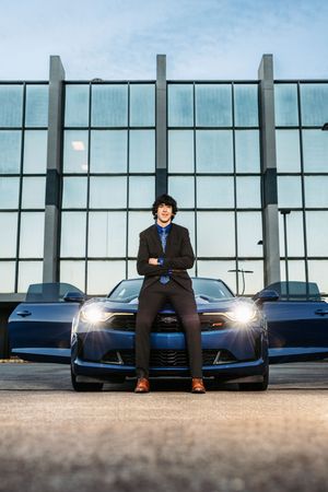 A series of photos showing a parked black sports car with someone sitting on its hood against a modern glass building.