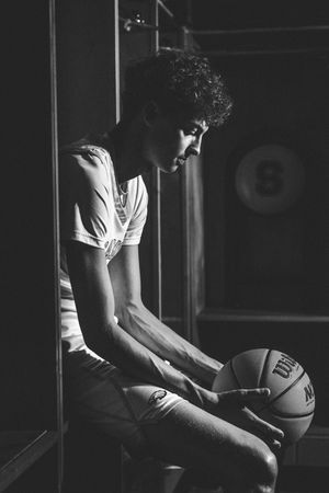 A black and white photo sequence shows hands holding a basketball in dramatic lighting.