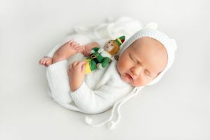 Minimalist newborn photography series on white background showing sleeping baby in angelic poses.