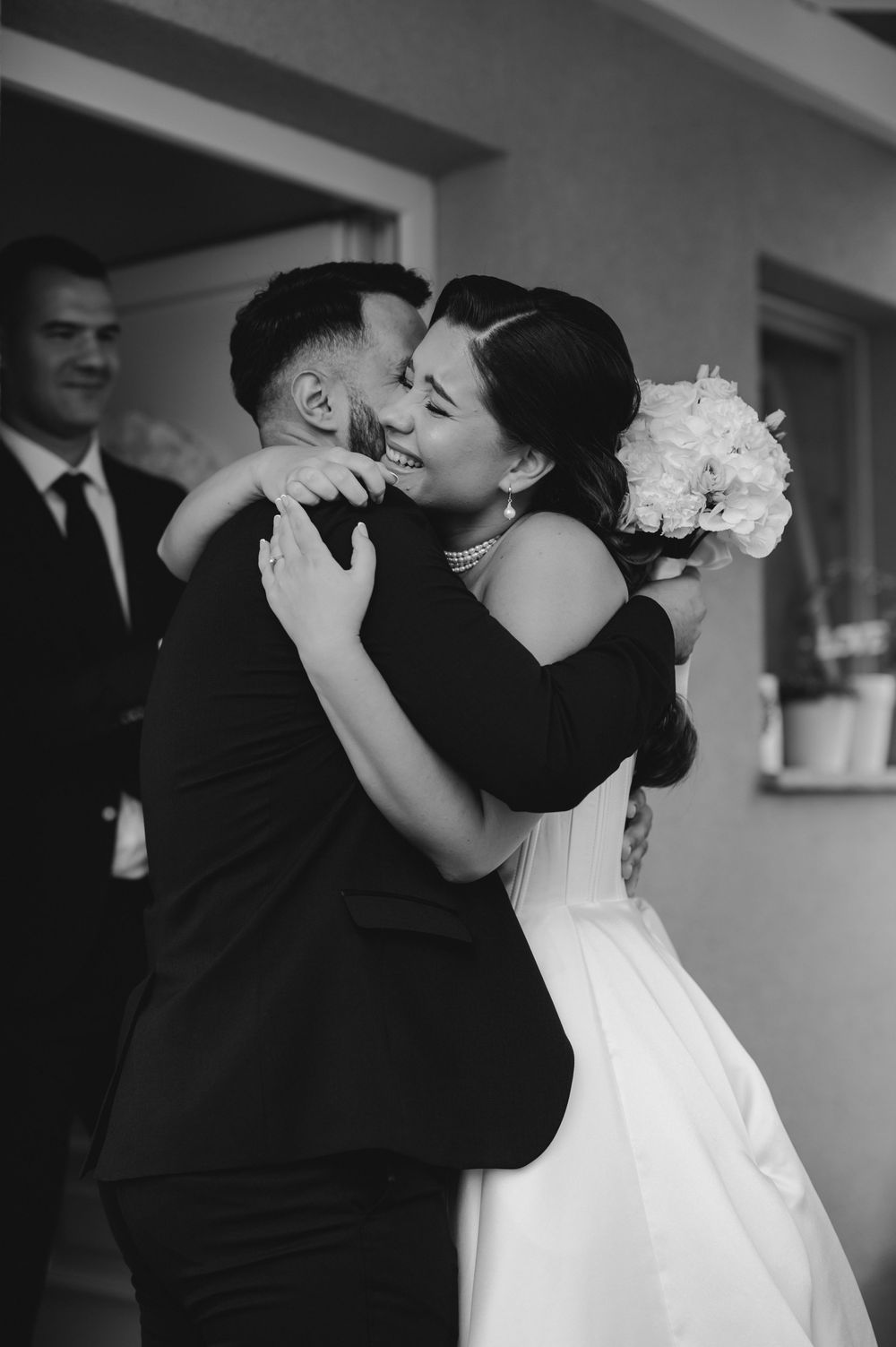 Black and white wedding photo series capturing intimate moments between newlyweds in formal attire.