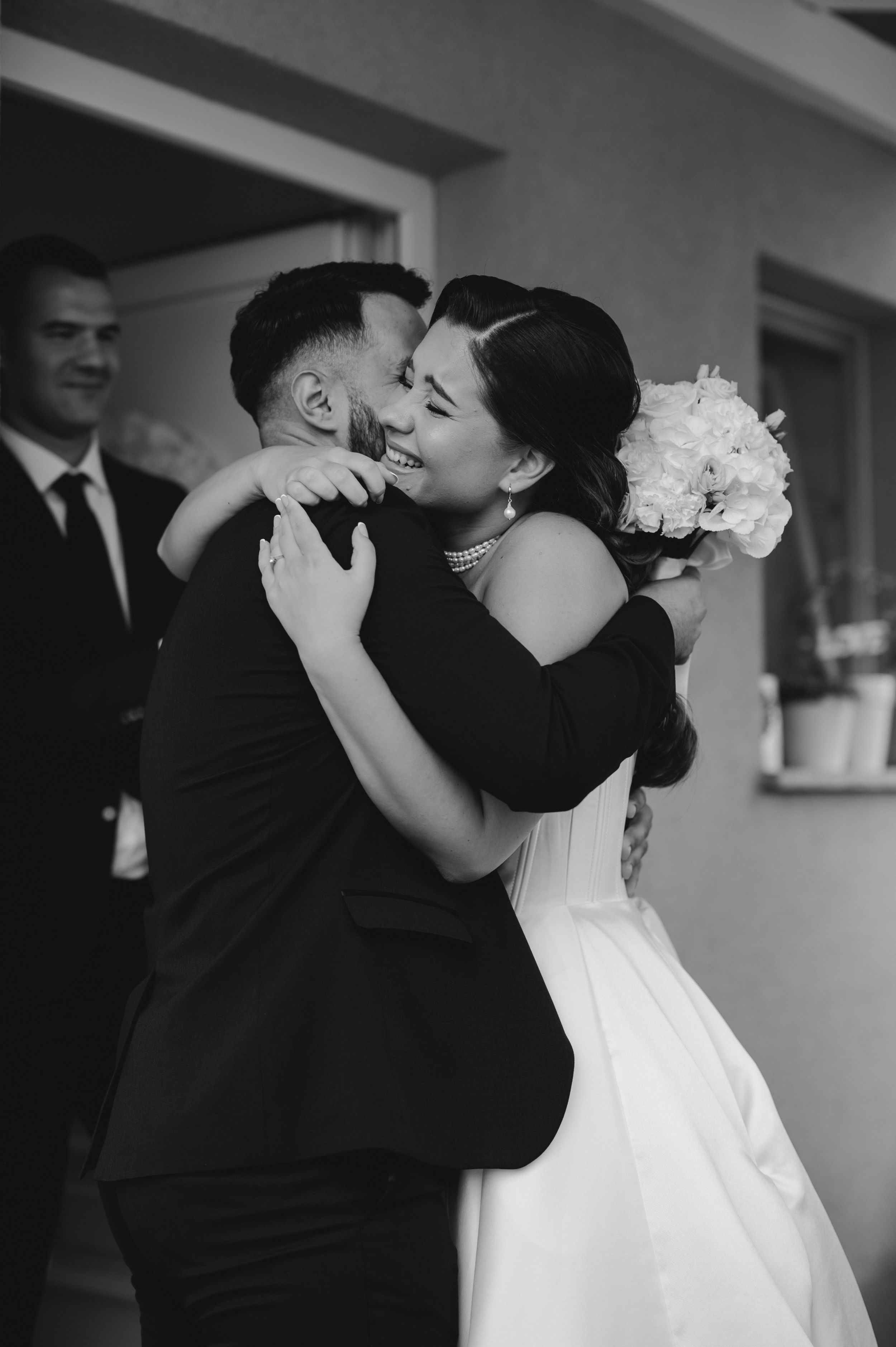 Black and white wedding photo series capturing intimate moments between newlyweds in formal attire.