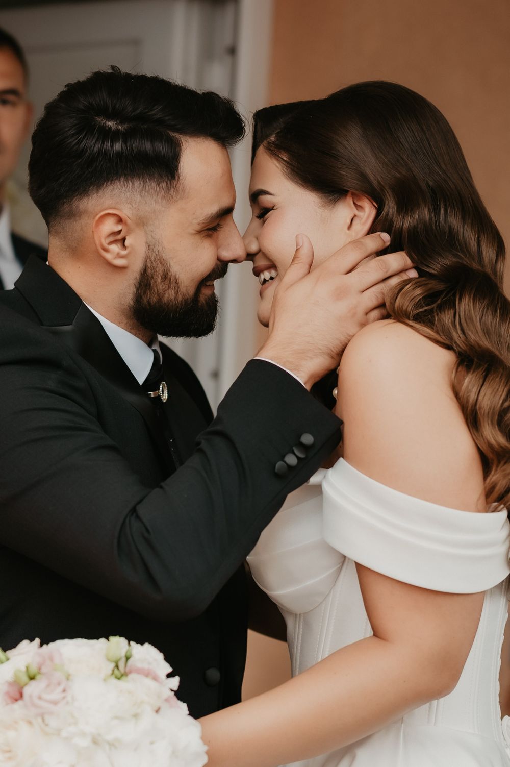 Close-up romantic wedding photos showing tender moments between newlyweds in black and white formal attire.