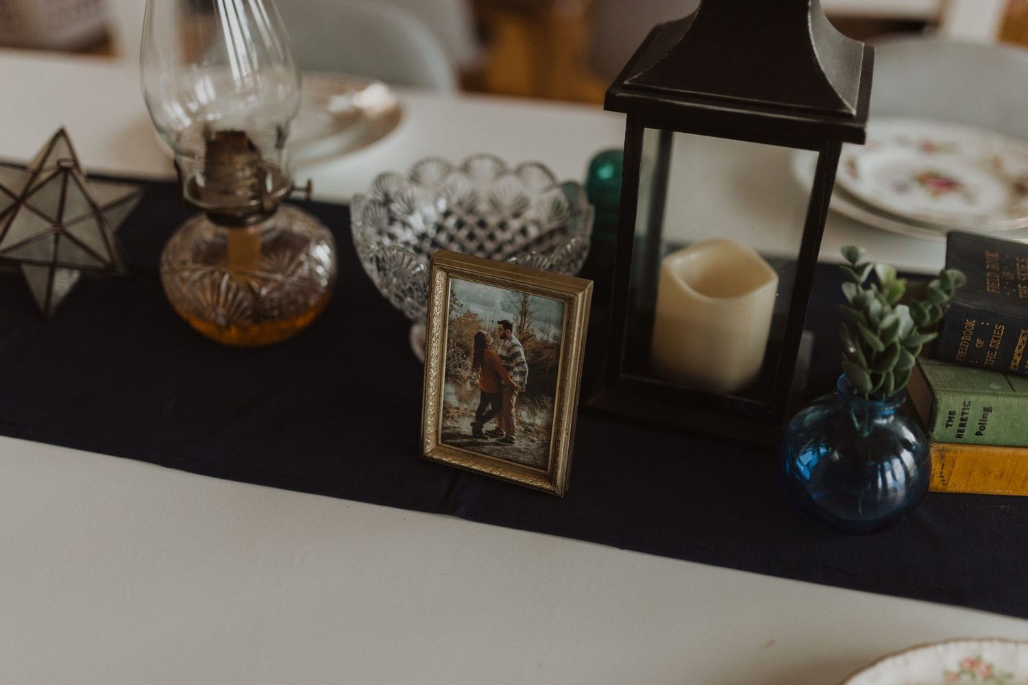 Decorative vintage items and picture frames arranged on shelving with soft lighting.