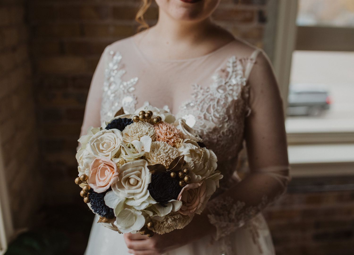 Close-up of a bridal bouquet featuring white and blush roses with dark accents.