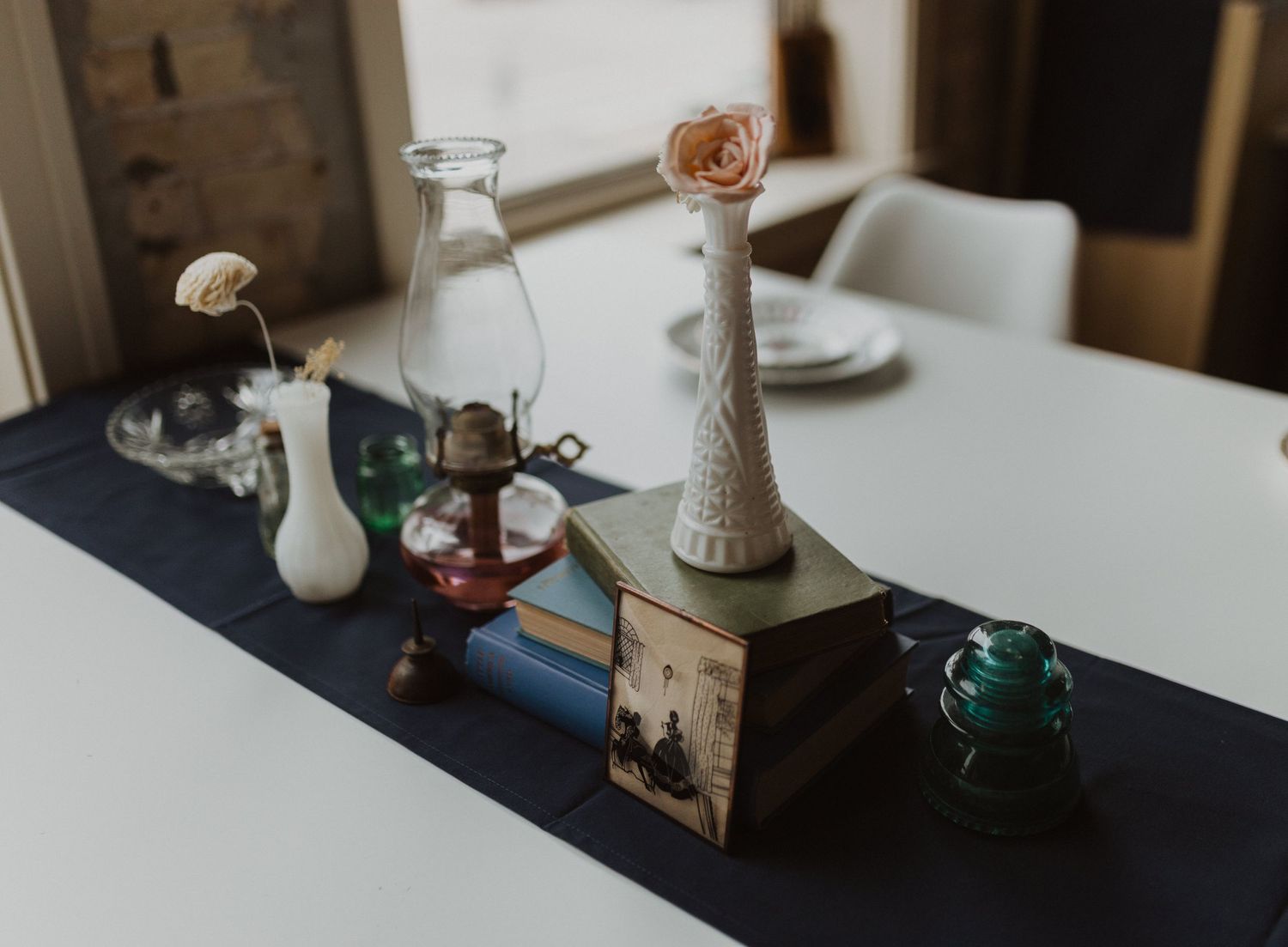Vintage decor items including glass bottles, vases, and decorative objects arranged on a white surface.