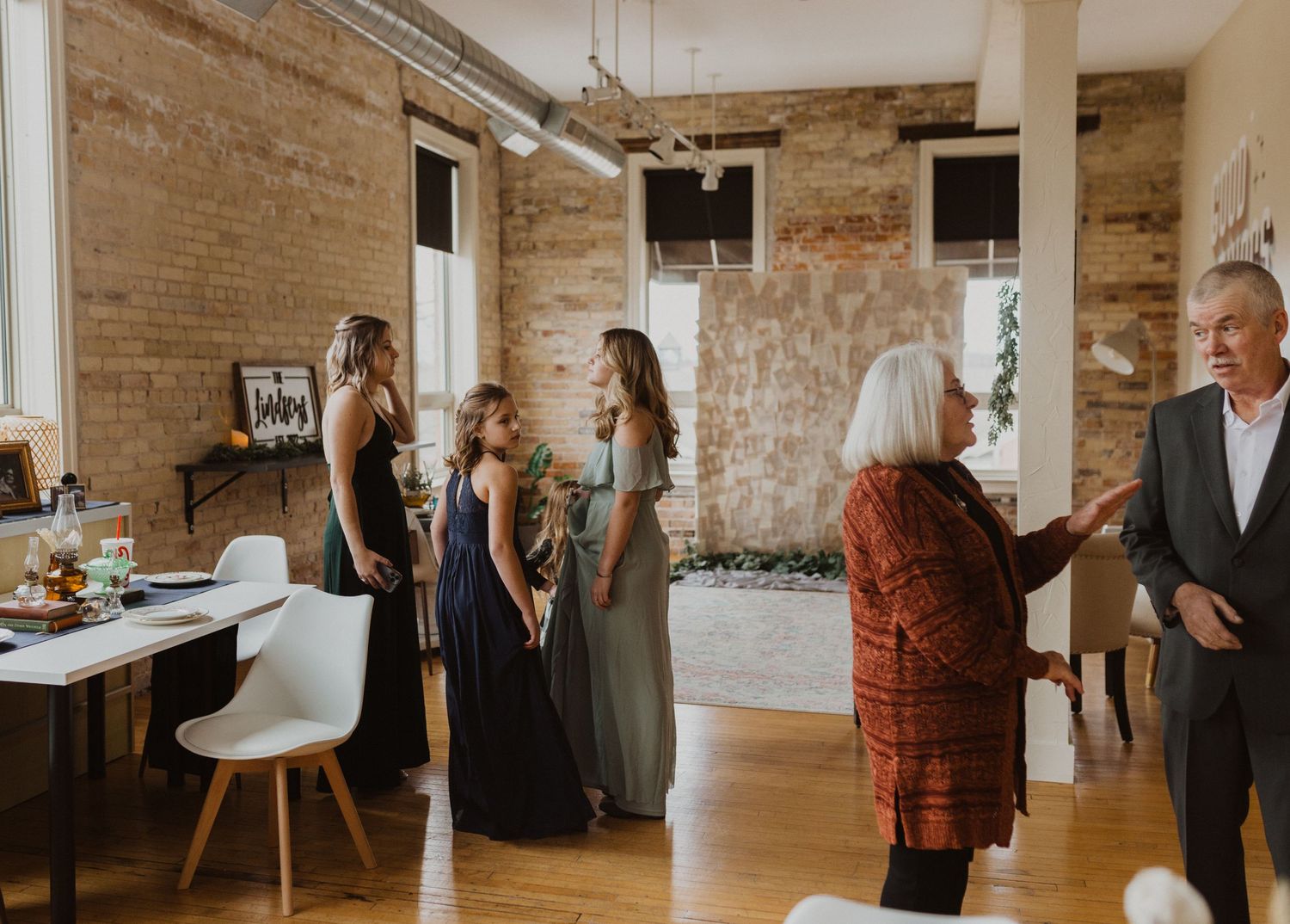 Wedding ceremony in a rustic brick-walled venue with hardwood floors and natural lighting.