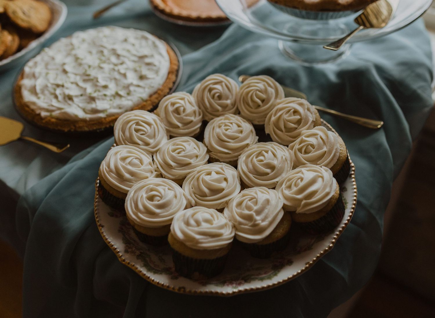 Beautifully decorated cupcakes with swirled frosting arranged on serving platters.
