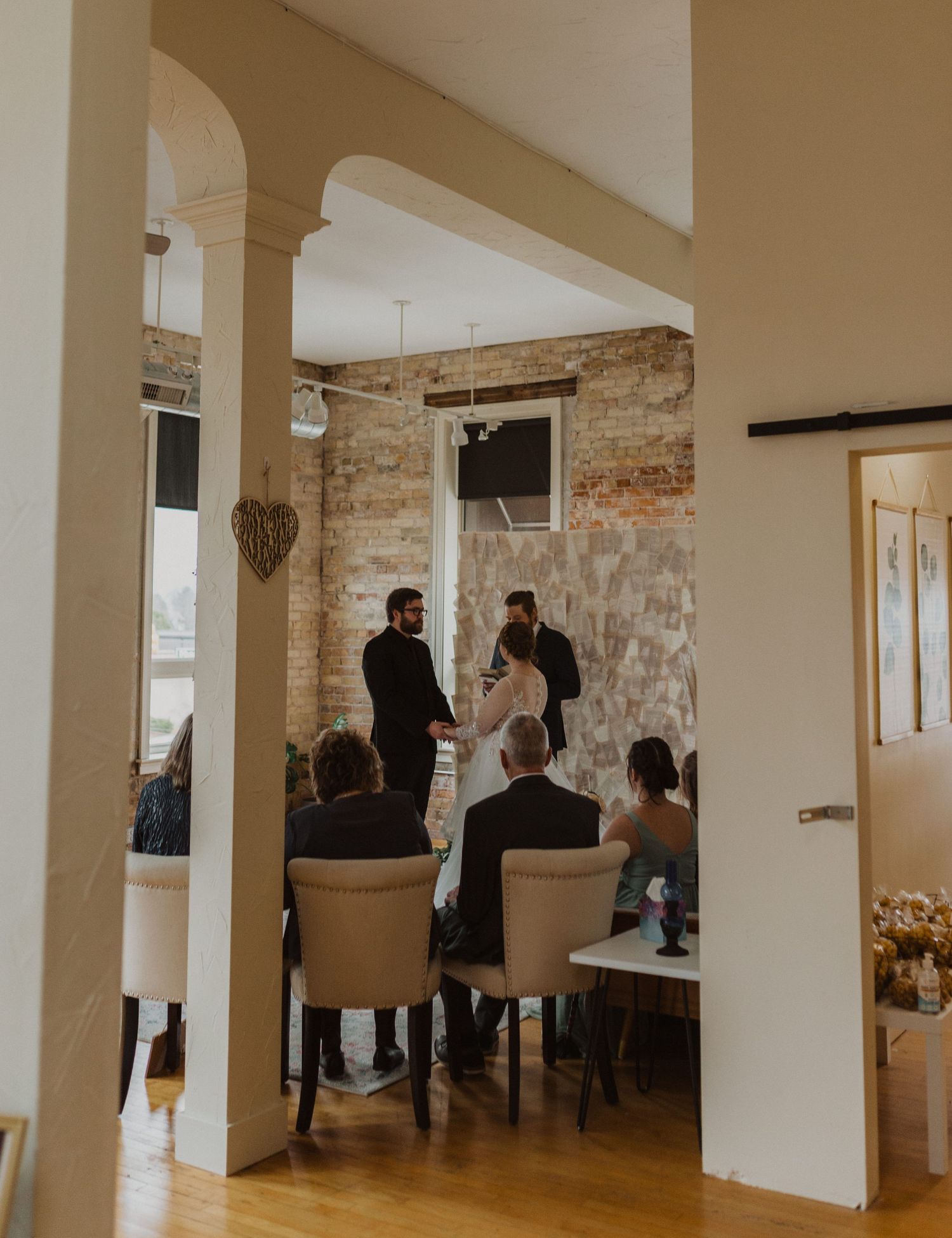 Modern wedding venue interior with white columns and exposed brick architectural details.