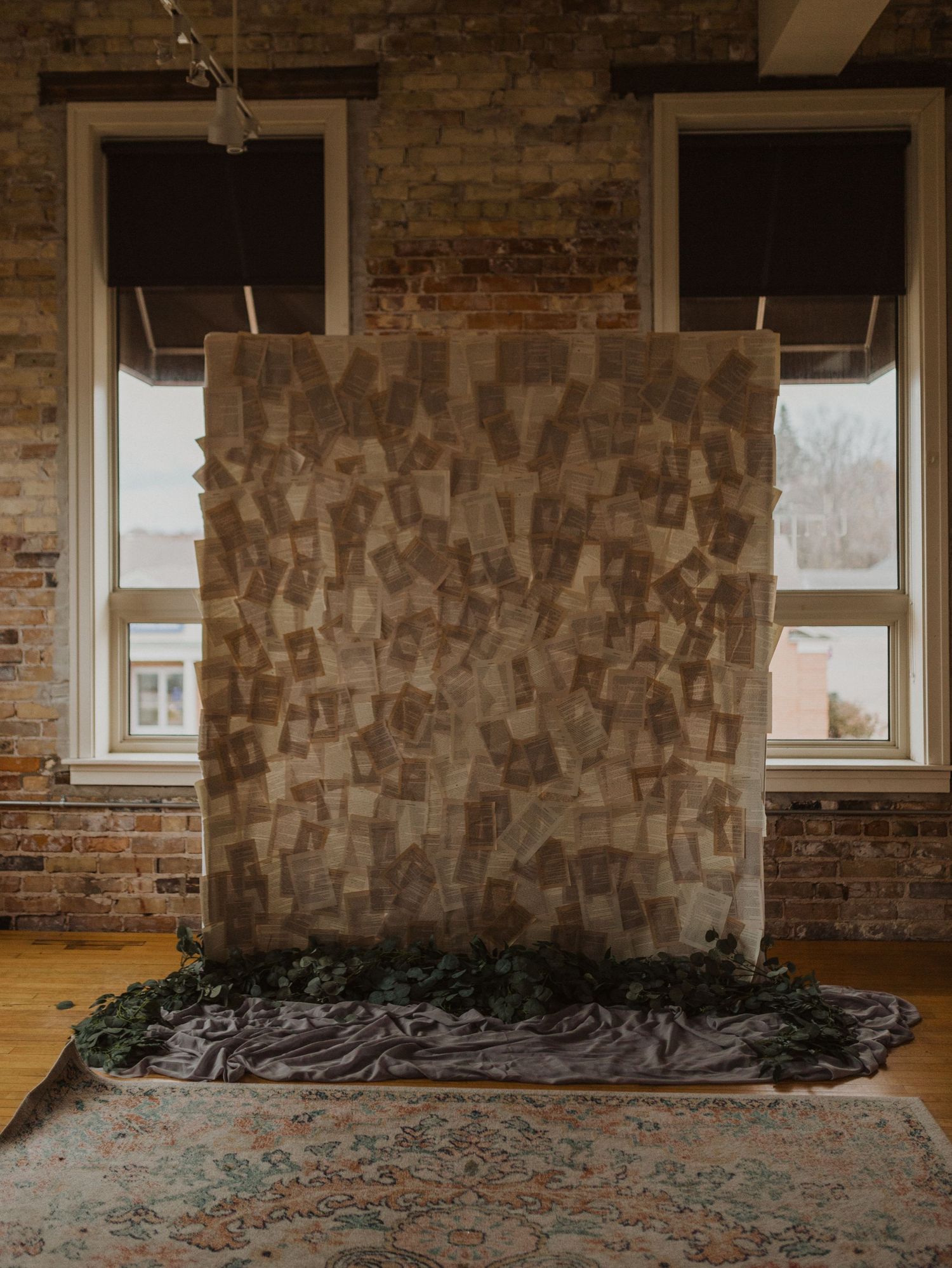 Exposed brick wall interior with windows and textured wall treatment in an empty room.