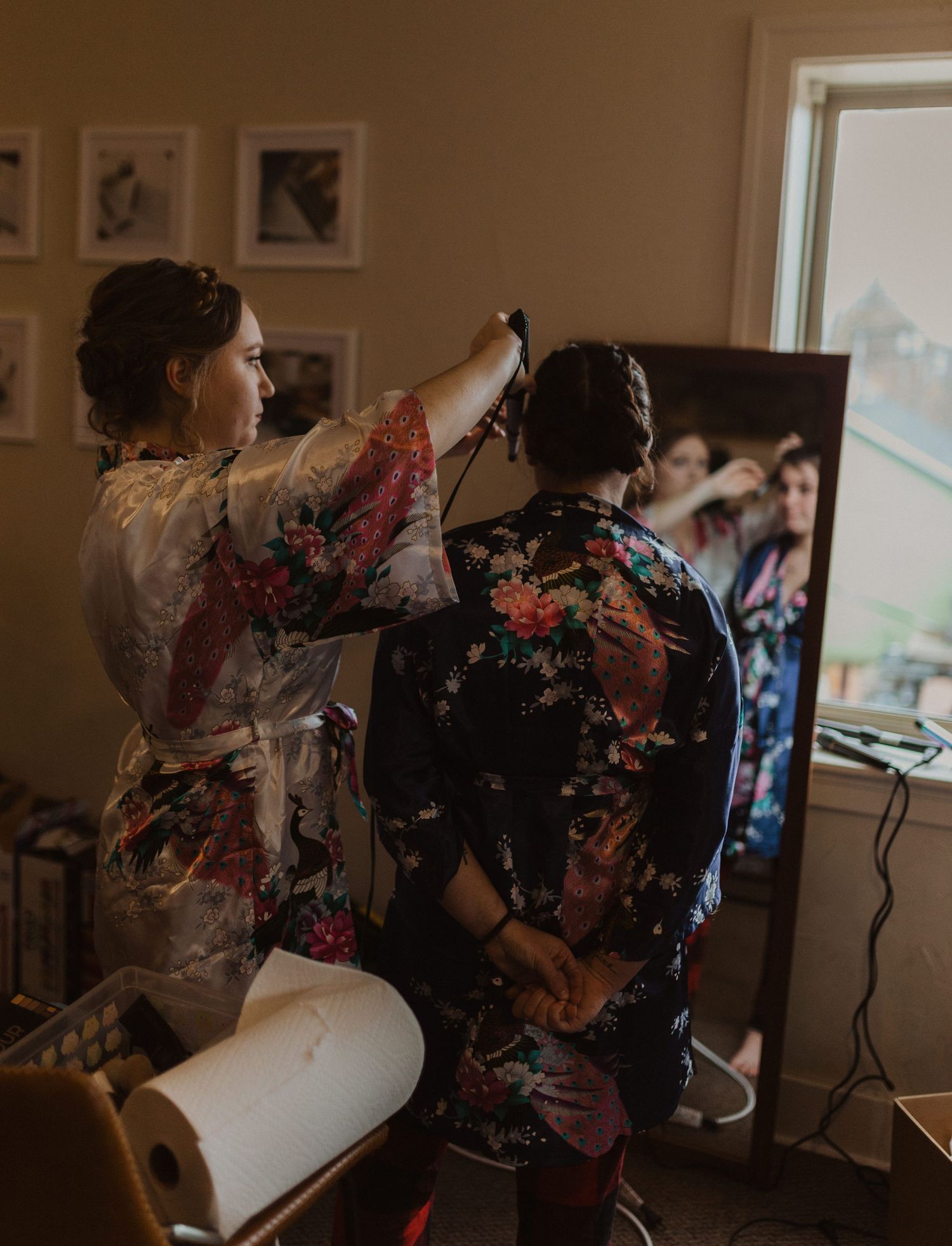 Wedding preparation scene with floral robes and styling tools.